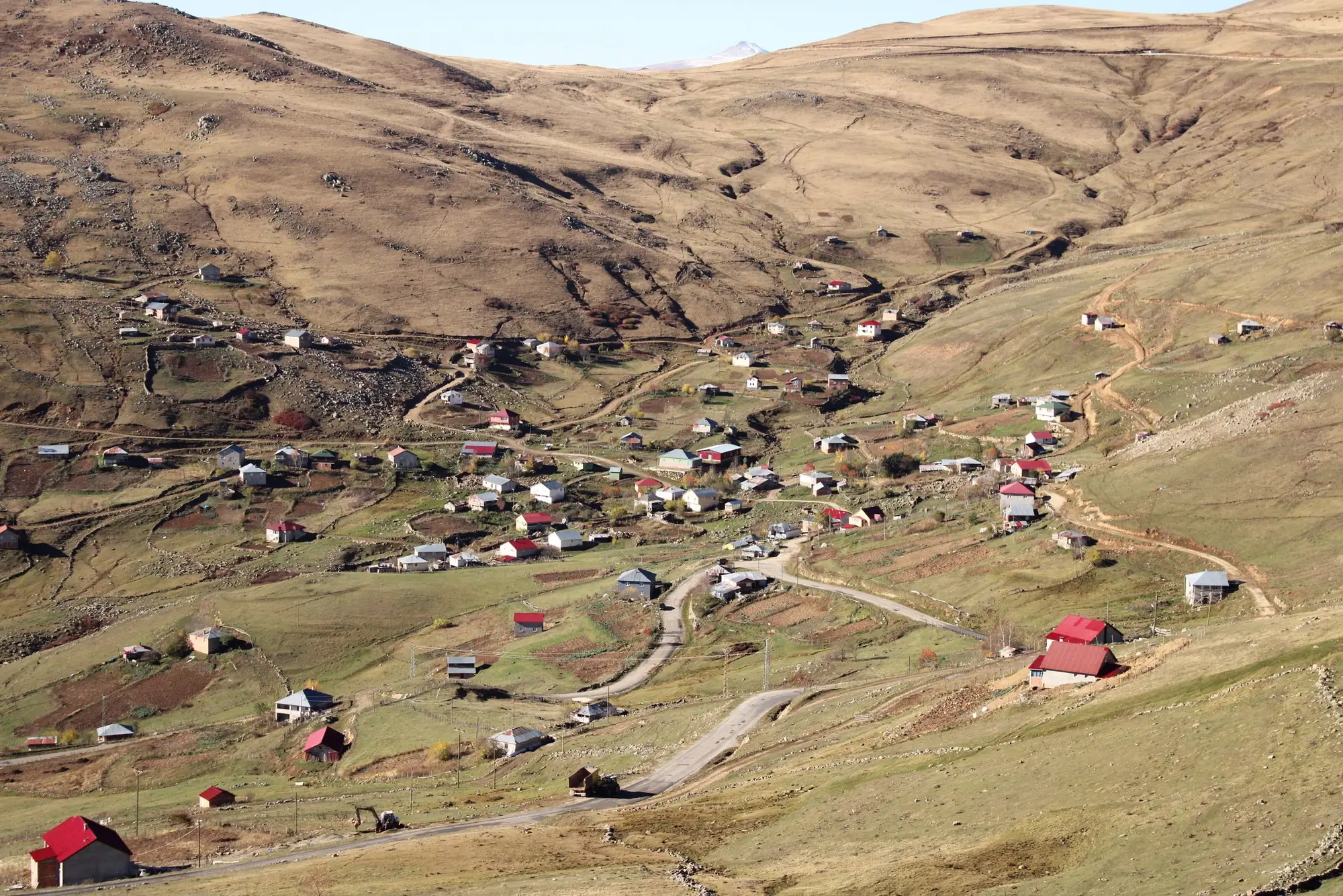 Houses scattered across a dry upland valley, linked by dirt tracks
